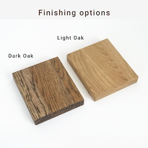 May include: Two rectangular wooden blocks, one in dark oak and the other in light oak, are displayed against a white background. The text "Finishing options" and "Dark Oak" and "Light Oak" are visible.
