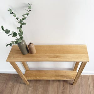 Solid oak hallway console table against white wall