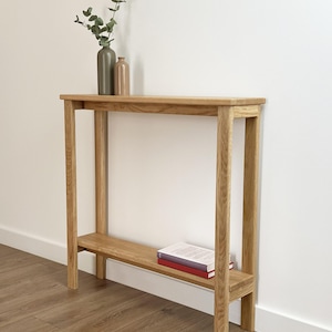 Slim Scandinavian entryway table with decorative vases and books