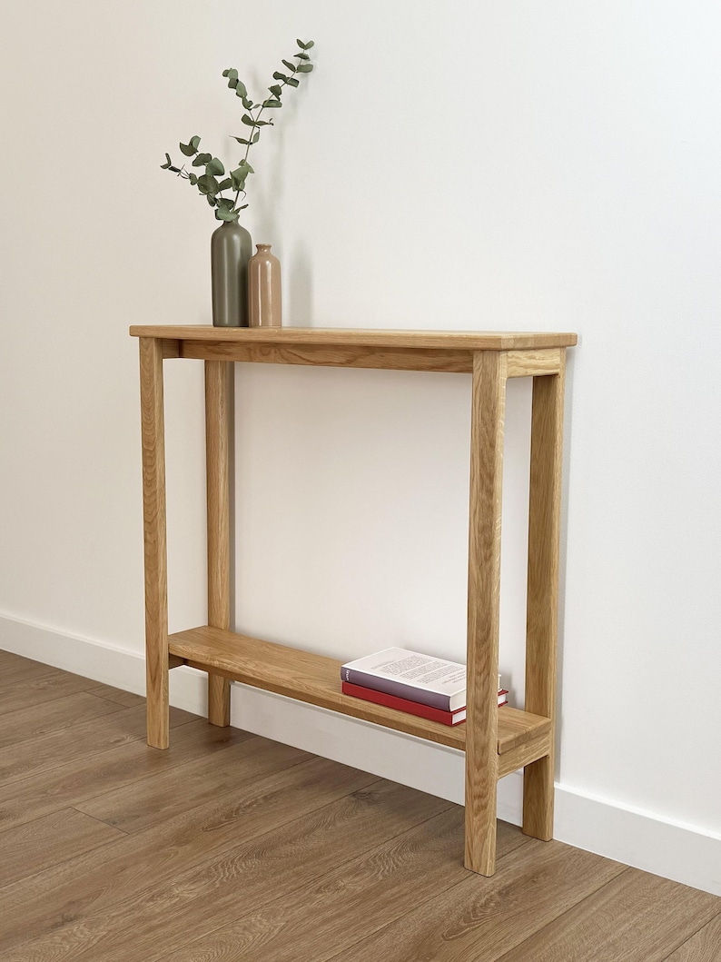 Slim Scandinavian entryway table with decorative vases and books
