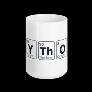 以下が含まれることがあります： 周期表の元素、イットリウム (Y)、トリウム (Th)、酸素 (O) がプリントされた白いセラミックマグカップ。 円筒形で光沢のある仕上がりで、コーヒーやお茶に最適です。