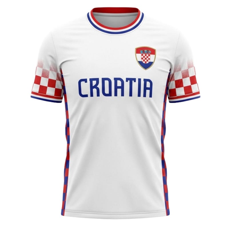 May include: White Croatia soccer jersey with blue "CROATIA" text across the chest. The jersey features red and white checkered patterns on the sleeves and a Croatian coat of arms emblem. The collar and sleeve cuffs have red and blue trim.