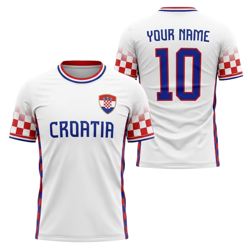 May include: White Croatia soccer jersey with blue and red accents. The front displays "CROATIA" in blue, the Croatian coat of arms, and a red and white checkered pattern on the sleeves. The back has "YOUR NAME" and the number "10" in blue.