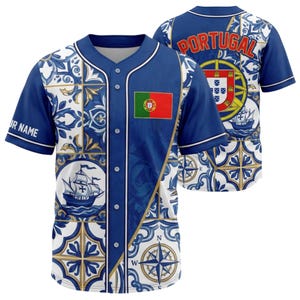 May include: A blue baseball jersey with a white and blue tile pattern, a Portuguese flag patch, and the word "PORTUGAL" on the back. The jersey features a button-up front and short sleeves. The design includes a compass rose and a ship.