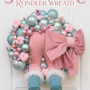 Peut inclure: Une couronne décorative intitulée Pastel Whimsy Reindeer Wreath composée d'ornements bleu clair et roses, de boules de coton et de formes de bonbons. Un grand nœud en tissu rose et des pattes de renne en peluche avec des bottes bleues sont fixés.