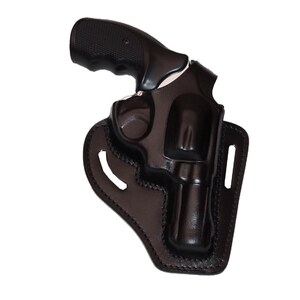 Könnte beinhalten: Ein schwarzer Revolver in einer schwarzen Lederholster. Die Holster ist so konzipiert, dass sie die Waffe sicher aufnimmt, mit einer geformten Form und Nahtdetails. Der Griff der Waffe ist sichtbar, und das Gesamtdesign deutet auf die Aufbewahrung von Schusswaffen hin.