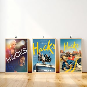 Könnte beinhalten: Drei gerahmte Poster mit der HBO Max-Serie "Hacks". Die Poster haben einen Holzrahmen. Das erste Poster zeigt das Wort "HACKS" in einem sternförmigen Neonzeichen. Das zweite Poster zeigt das Wort "Hacks" in Gelb. Das dritte Poster zeigt das Wort "Hacks" in Gelb.