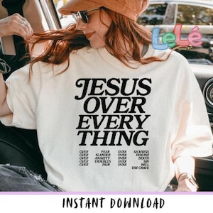 May include: Cream-colored t-shirt with the text "JESUS OVER EVERYTHING" in large black letters. Below, smaller text lists various challenges. The words "INSTANT DOWNLOAD" are at the bottom. The shirt is worn by a person.