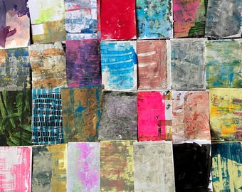 May include: A collection of small, rectangular abstract art pieces. Each piece features a unique combination of colors and textures, including red, blue, pink, and green. The artwork appears to be created with paint and mixed media techniques.