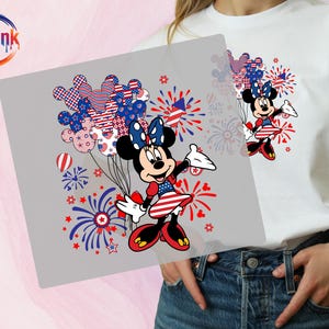 K&ouml;nnte beinhalten: Ein wei&szlig;es T-Shirt mit einem Grafikdruck von Minnie Maus in einem patriotischen rot-wei&szlig;-blauen Outfit. Das Design zeigt Mickey-f&ouml;rmige Luftballons mit Sternen- und Streifenmustern, rote und blaue Feuerwerke sowie das BoldInk DTF-Logo.