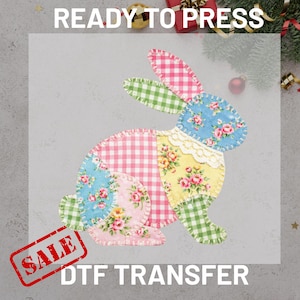 May include: A colourful DTF transfer featuring a patchwork bunny design. The bunny is made of various patterned fabrics, including gingham and floral prints. The text "READY TO PRESS" and "SALE DTF TRANSFER" are visible.