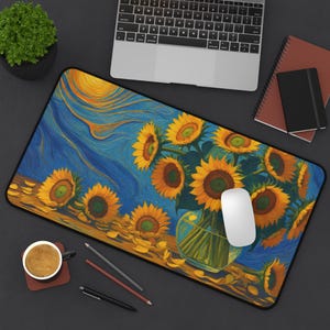 May include: A rectangular desk mat featuring a vibrant painting of sunflowers in a vase against a blue and yellow background. The artwork resembles a Van Gogh style. A white computer mouse rests on the mat, alongside a laptop and stationery.