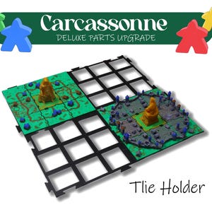Könnte beinhalten: Carcassonne Deluxe Parts Upgrade Brettspiel-Kartenhalter. Das Bild zeigt einen schwarzen Kartenhalter mit grünen und grauen Spielkarten. Der Text "Carcassonne Deluxe Parts Upgrade" steht oben und "Tile Holder" unten.