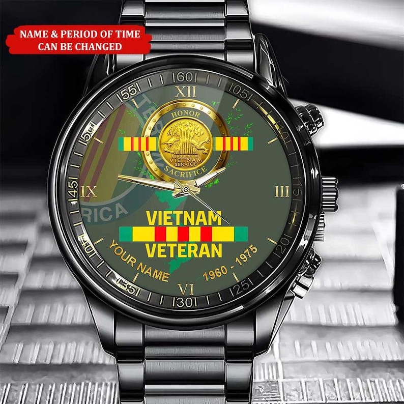 Puede incluir: Un reloj de pulsera negro con una esfera verde con el texto "VIETNAM VETERAN" y un emblema dorado. El reloj tiene una correa de acero inoxidable y el texto "NAME & PERIOD OF TIME CAN BE CHANGED".