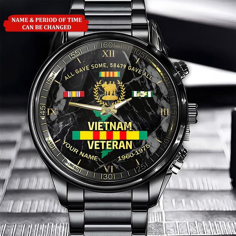 May include: A black wristwatch with a marble-patterned face. The watch face features the text "VIETNAM VETERAN" and a map of Vietnam. The watch also displays the text "ALL GAVE SOME, 58479 GAVE ALL" and the years "1960-1975".