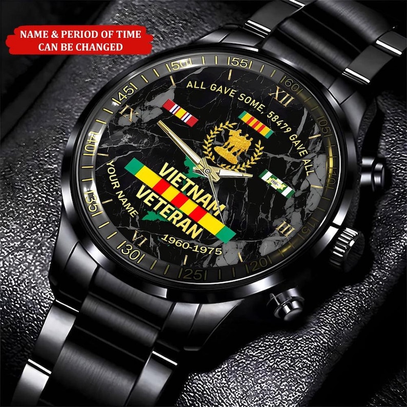 May include: Black wristwatch with a marble-patterned face. The watch face features the text "VIETNAM VETERAN 1960-1975" and military ribbons. The watch has a black metal band and a gold-colored bezel.