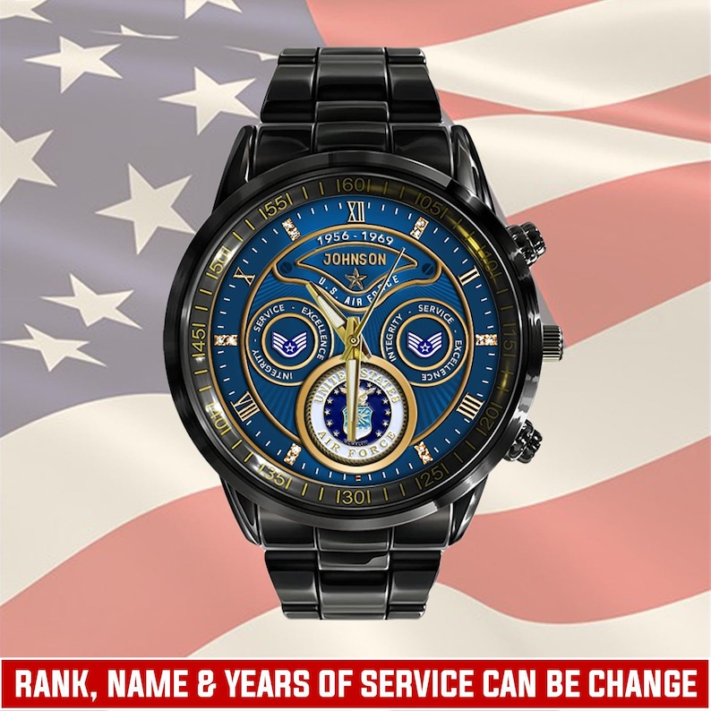 May include: A black stainless steel wristwatch with a blue dial featuring the United States Air Force emblem, gold-tone hands, and Roman numeral markers. The dial displays the text 1956-1969, JOHNSON, U.S. AIR FORCE, SERVICE, EXCELLENCE, and INTEGRITY.