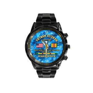 May include: Black wristwatch with a blue marble-effect face. The watch face features the text "Vietnam Veteran 1965-1966" and the American and Vietnamese flags. The watch also has the text "Been there - Do that and damn proud of it."