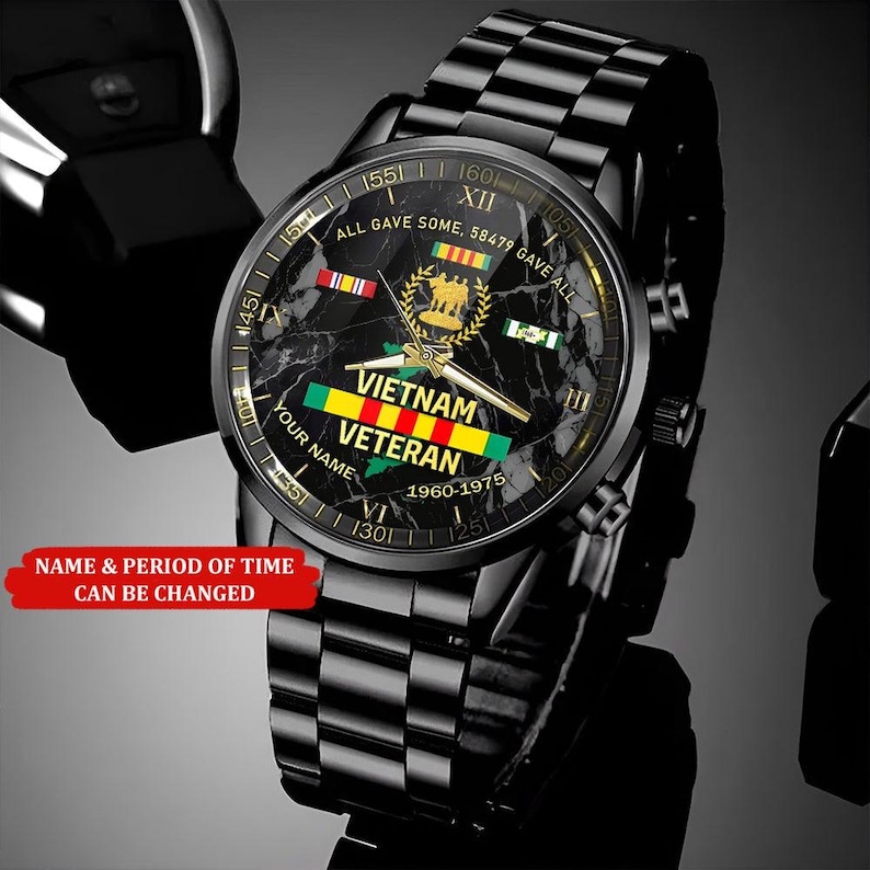 May include: Black wristwatch with a checkered band and a round face. The watch face features the text "Vietnam Veteran" and the years "1960-1975". The watch also has the text "All gave some, 58479 gave all".