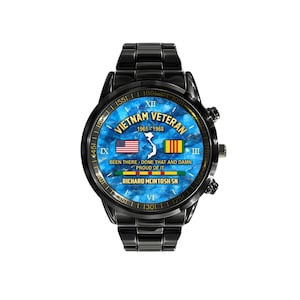 May include: Black wristwatch with a blue face featuring the text "Vietnam Veteran 1965-1968". The watch face includes the American and Vietnamese flags. The watch band and case are black.