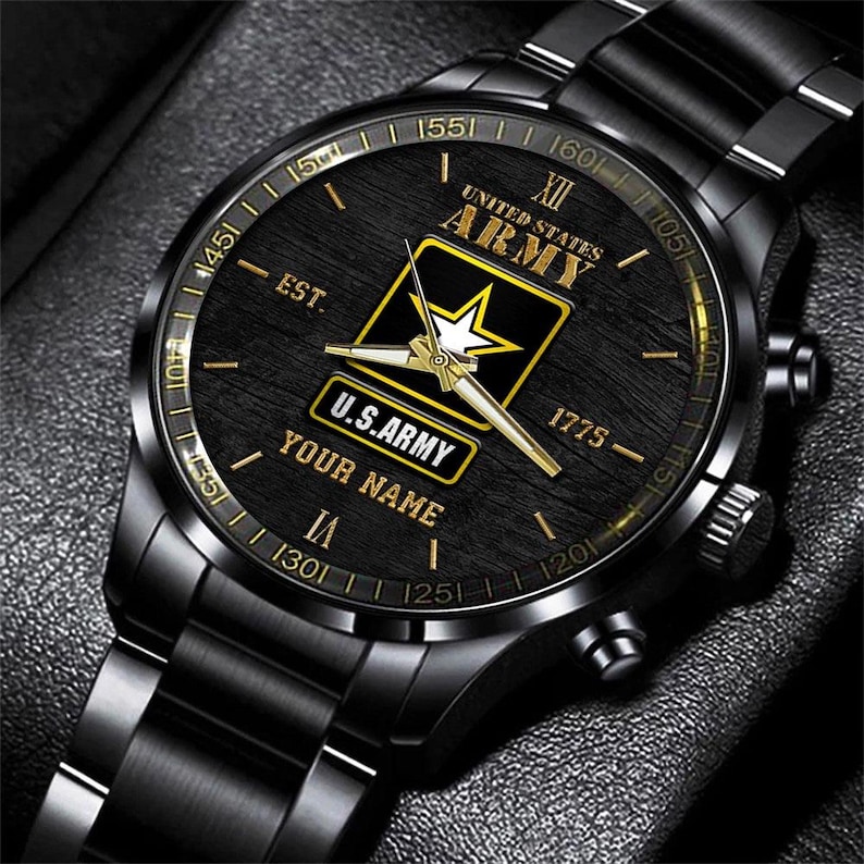 May include: Black wristwatch with a black band and a black face. The watch face features the words "UNITED STATES ARMY" and "U.S. ARMY" in gold lettering, along with a gold star emblem. The watch also has the text "YOUR NAME".
