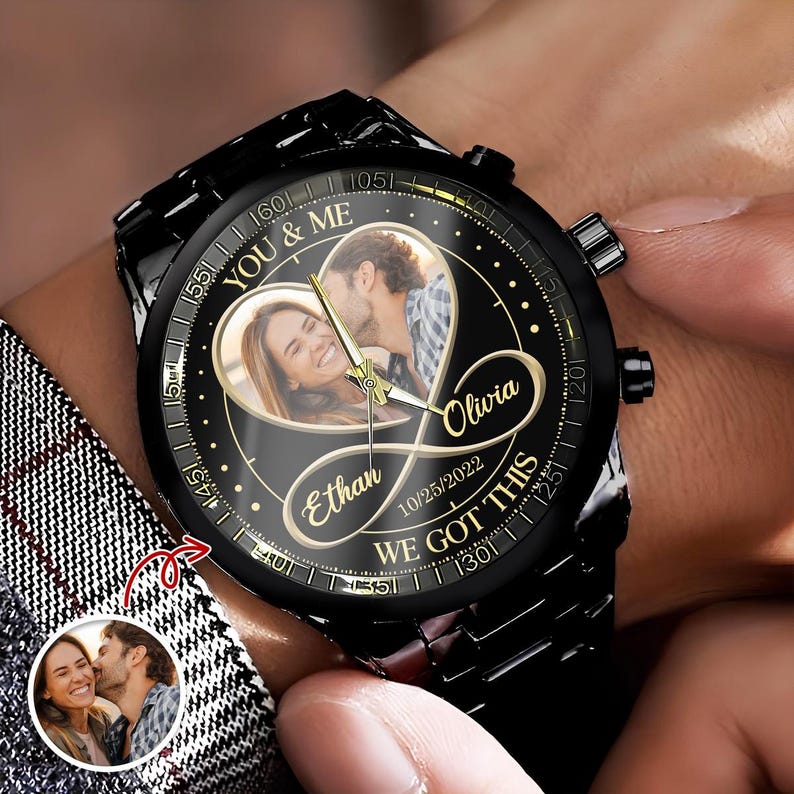May include: A black wristwatch with a custom photo dial featuring a couple inside a gold heart and infinity symbol. The watch face displays the text YOU & ME, Olivia, Ethan, 10/25/2022, and WE GOT THIS in gold lettering with gold hands.