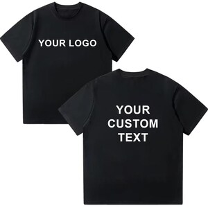 May include: Two black t-shirts with white text. One shirt displays "YOUR LOGO" on the front. The other shirt shows "YOUR CUSTOM TEXT" on the back. Both shirts have short sleeves and a crew neck.