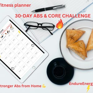 May include: A digital fitness planner on a tablet with the text "30-DAY ABS & CORE CHALLENGE." The image includes a pen, glasses, a plate with pastries, and a cup of coffee. The text "Build Stronger Abs from Home" is also visible.