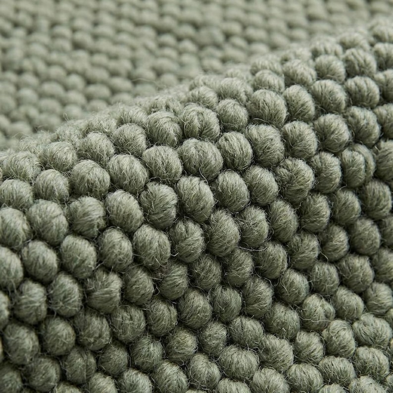 Close-up of chunky wool rug showing thick knitted wool fibers, natural handmade rug for rustic and modern homes