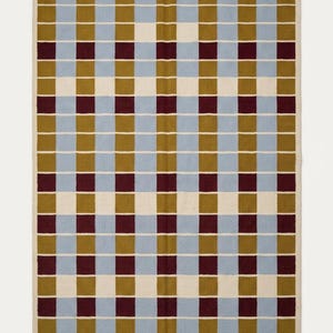 Full overhead view of the geometric grid rug highlighting the ivory grid lines separating mustard gold, powder blue and wine red squares.