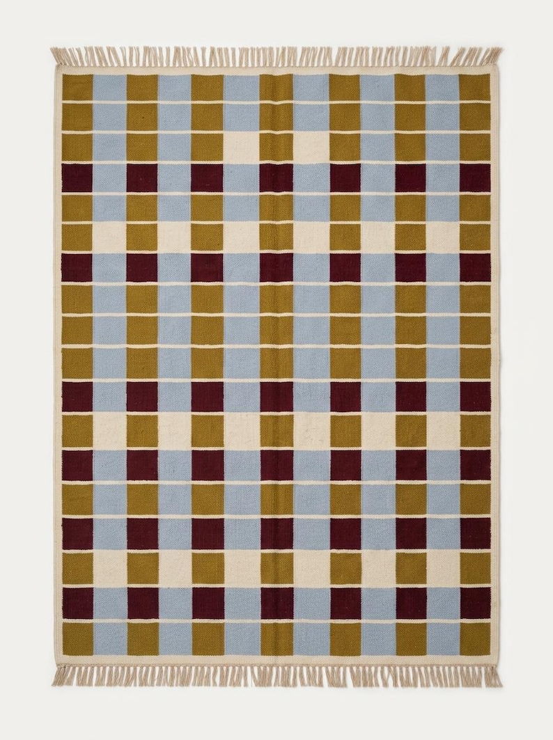 Full overhead view of the geometric grid rug highlighting the ivory grid lines separating mustard gold, powder blue and wine red squares.