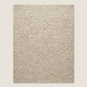 Handmade style chunky wool rug adding warmth and depth to modern Scandinavian home interior