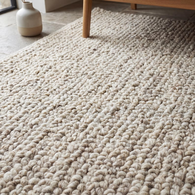 Chunky wool rug with thick looped texture in neutral beige tones for cozy minimalist living room decor