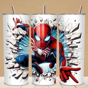 Könnte beinhalten: Drei weiße Edelstahlbecher mit einer Spiderman-Grafik. Das Design zeigt Spiderman in einer dynamischen Pose, der durch eine Wand bricht. Die Figur trägt einen rot-blauen Anzug mit einem weißen Spinnenemblem. Jeder Becher hat einen silbernen Strohhalm.
