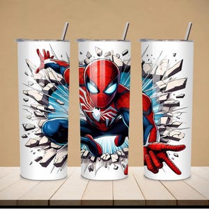 May include: Three white insulated tumblers with a Spider-Man design. The superhero is depicted in a dynamic pose, breaking through a wall. The design features red, blue, and white colors, with a silver straw and lid.