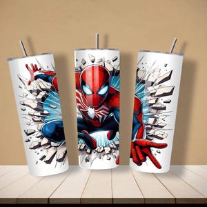 May include: Three white insulated tumblers featuring a Spider-Man design. The superhero is depicted in his classic red and blue suit, breaking through a wall. Each tumbler has a silver straw and lid.
