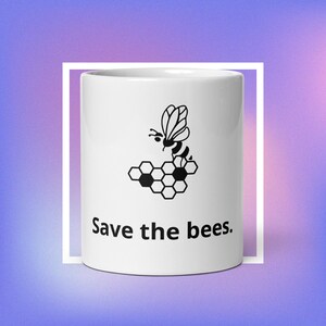 May include: White ceramic mug with a black illustration of a bee and honeycomb, with the text "Save the bees." The mug has a glossy finish and is set against a gradient purple and blue background.
