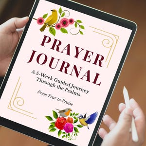 May include: A digital tablet showing a "Prayer Journal" with floral and bird illustrations. The text reads "A 5-Week Guided Journey Through the Psalms, From Fear to Praise." A stylus is held near the screen.