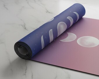 Pode incluir: Tapete de ioga enrolado com um design gradiente de rosa e roxo. A parte enrolada é azul escuro com formas de lua crescente brancas e estrelas. A parte desenrolada mostra as fases da lua.