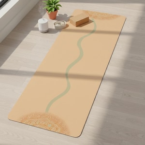 May include: A beige yoga mat with a light green wavy line down the center and decorative mandala patterns at each end. A wooden yoga block, a small potted plant, and a white essential oil diffuser are nearby.