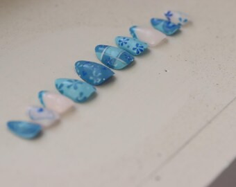 Juego de uñas postizas en gel con patrón azul.