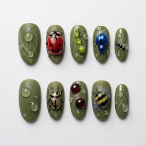 May include: Olive green nail art featuring various insect designs, including a ladybug, caterpillar, and bee. Each nail has a water droplet effect and leaf accents, creating a nature-inspired theme.