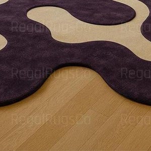 Modern Purple Abstract Wavy Rug in deep plum and beige tones, featuring curved organic shapes. Large 12x15ft contemporary area carpet perfect for living rooms or bedrooms, adding artistic style, warmth, and sophistication to any modern home interior.