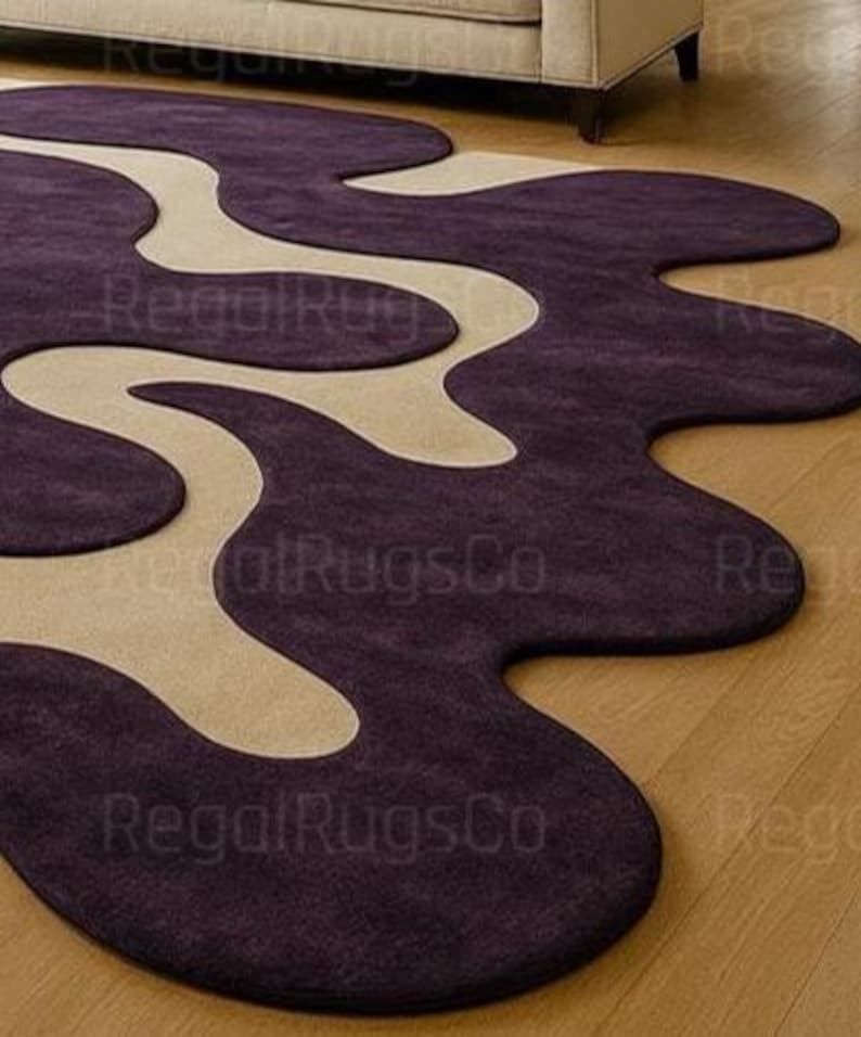 Modern Purple Abstract Wavy Rug in deep plum and beige tones, featuring curved organic shapes. Large 12x15ft contemporary area carpet perfect for living rooms or bedrooms, adding artistic style, warmth, and sophistication to any modern home interior.