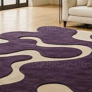 Modern Purple Abstract Wavy Rug in deep plum and beige tones, featuring curved organic shapes. Large 12x15ft contemporary area carpet perfect for living rooms or bedrooms, adding artistic style, warmth, and sophistication to any modern home interior.