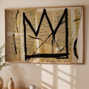 May include: A framed artwork featuring a black crown design on a background of layered paper with handwritten text. The artwork hangs above a wooden console table with a vase of greenery, a small vase, and a cup and saucer.