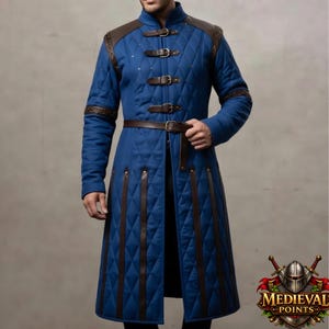 May include: A blue quilted coat with brown leather accents, shoulder pads, and a belt. The coat features diamond stitching and three buckle closures. The coat is long and has vertical brown leather strips down the front.