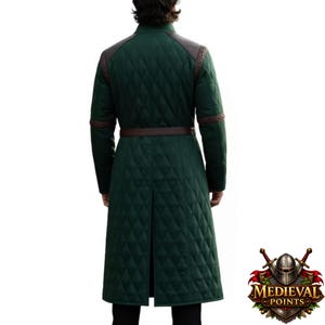 May include: A dark green quilted coat with brown leather accents on the shoulders and sleeves. The coat has a diamond pattern and a brown belt. The coat is long and reaches the knees. The Medieval Points logo is in the bottom right corner.