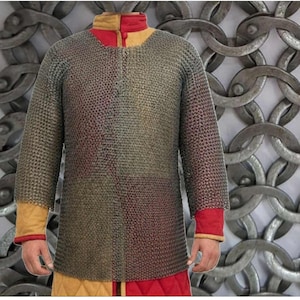 May include: A chainmail shirt with long sleeves. The shirt is made of small metal rings and has a round collar with red and yellow accents. The cuffs are red with yellow trim. The shirt is worn over red and yellow fabric.