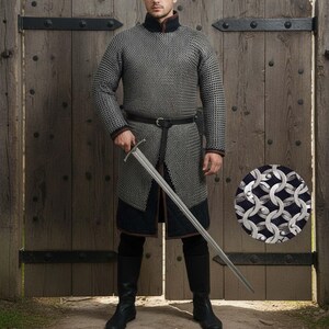 May include: A full-length image of a medieval chainmail shirt and pants, with a long sword. The chainmail is silver and black, with a black belt and boots. The background is a wooden door.